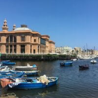 blue and white boats on sea viewing building