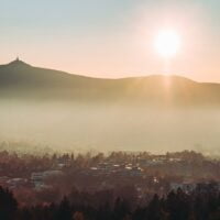 green trees and mountains during sunrise