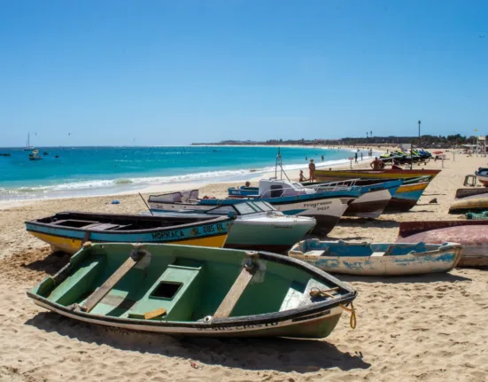 a group of boats sitting on top of a sandy beach