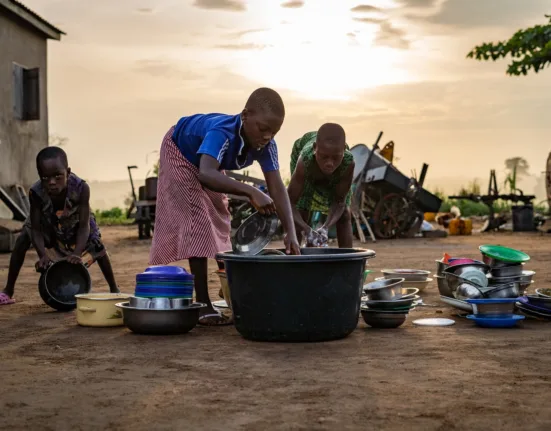 children washing dishes outside