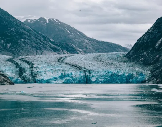 snow covered mountain near body of water