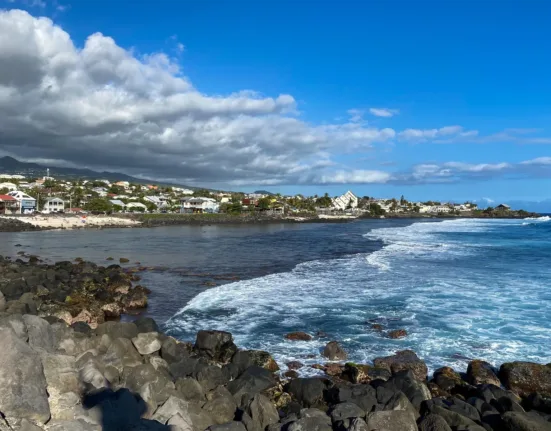 rocky shore under blue sky and white clouds during daytime