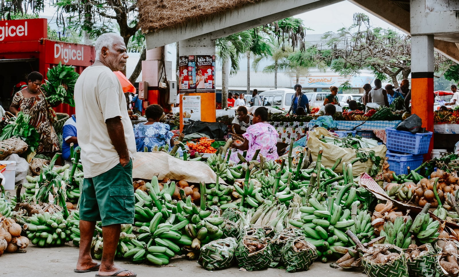 man standing in front of bananas