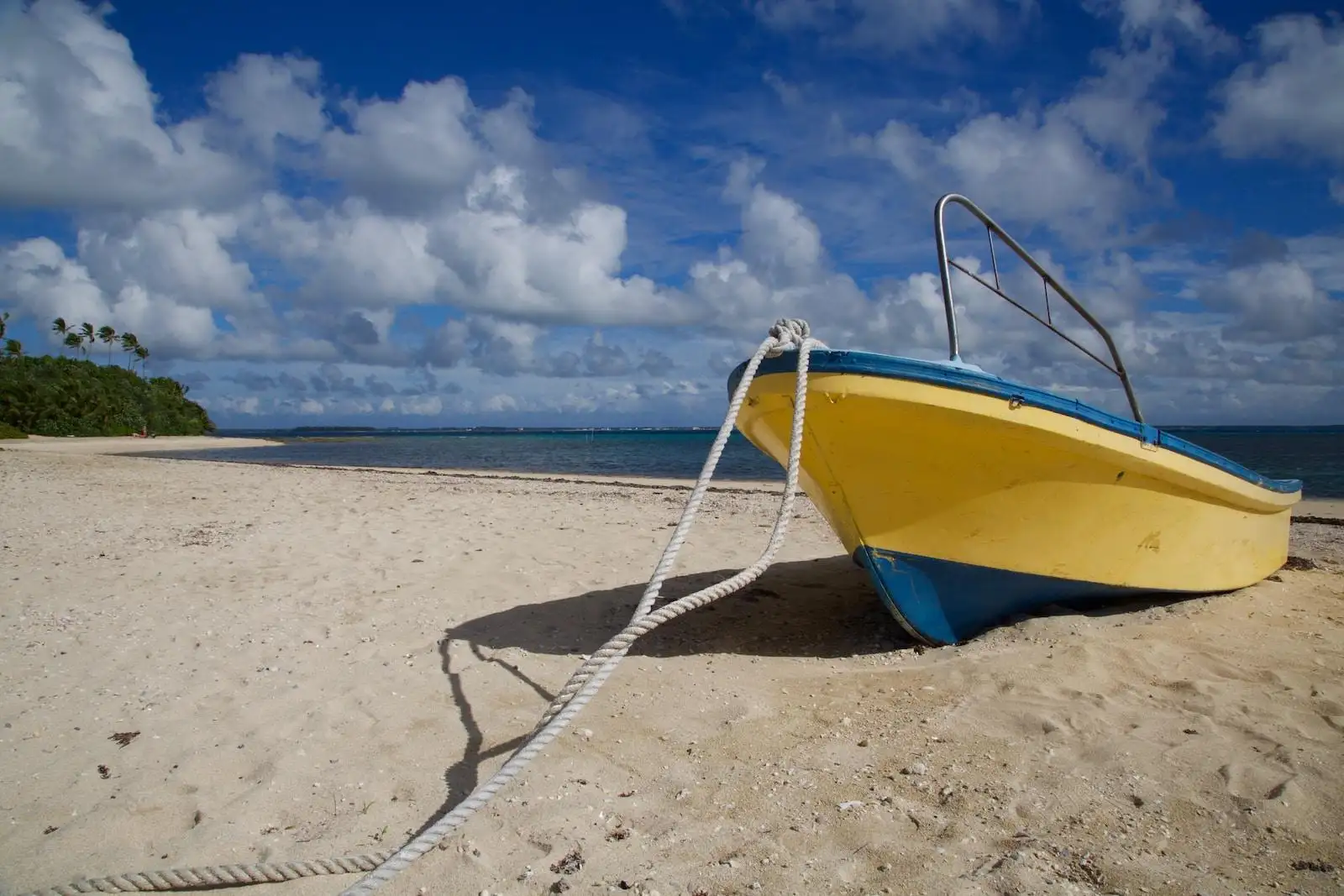 Photo by Vince Russell yellow and blue cuddy boat on seashore