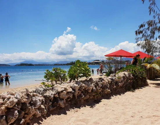 red and white house near beach under blue sky during daytime