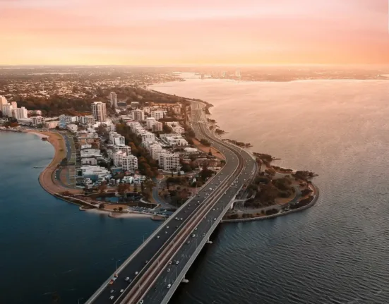 aerial view of city buildings near body of water during daytime