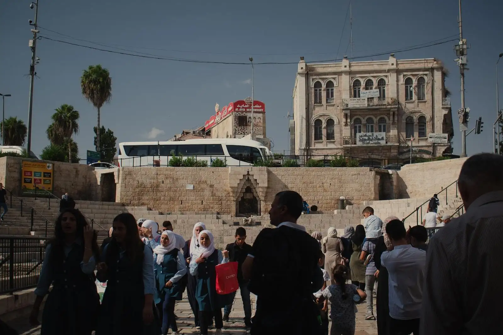 Photo by Levi Meir Clancy a group of people walking down a street next to a building