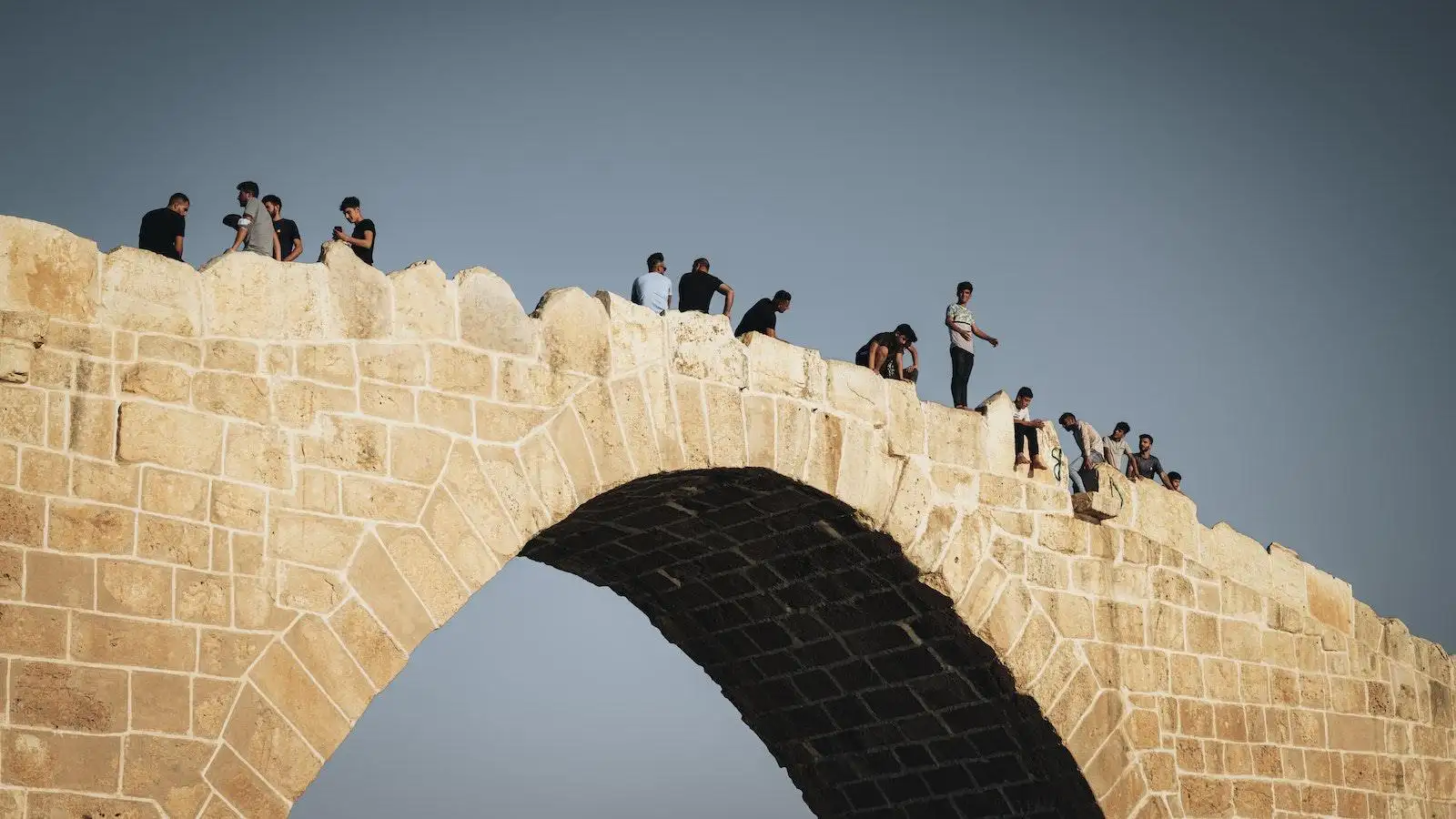 Photo by mohammad majid People Sitting on Concrete Bridge