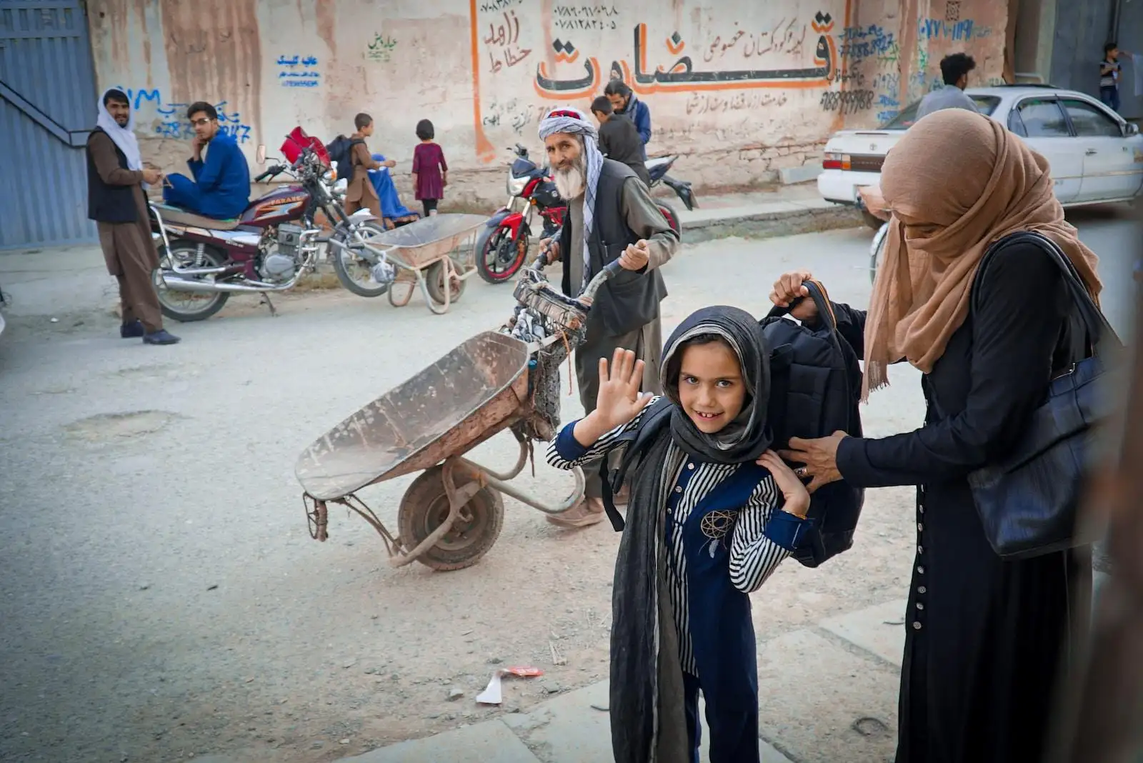 Photo by Wanman uthmaniyyah a group of people on a street with a wheelbarrow