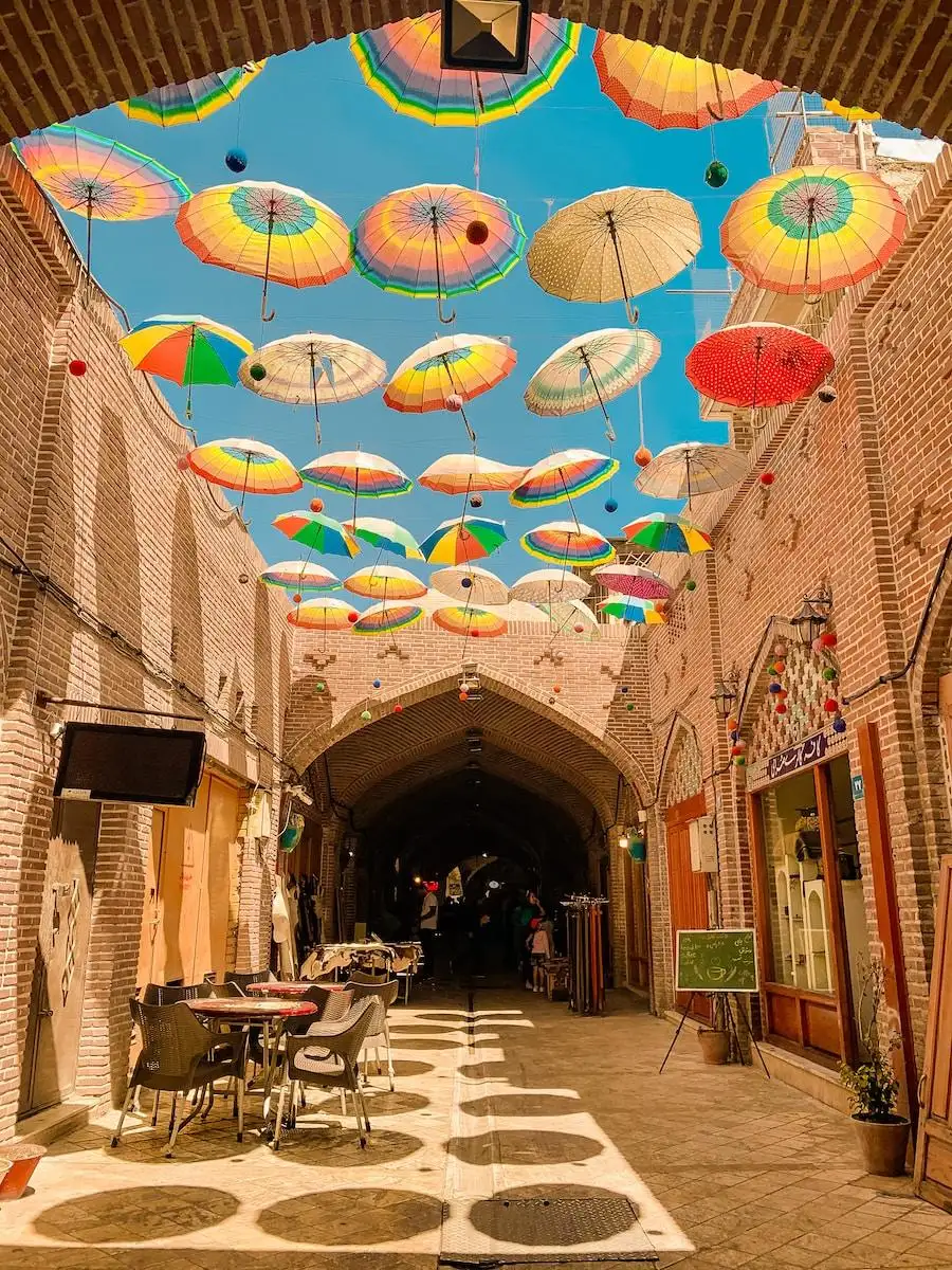 Photo by Omid Armin assorted-colored umbrellas hanging on alley
