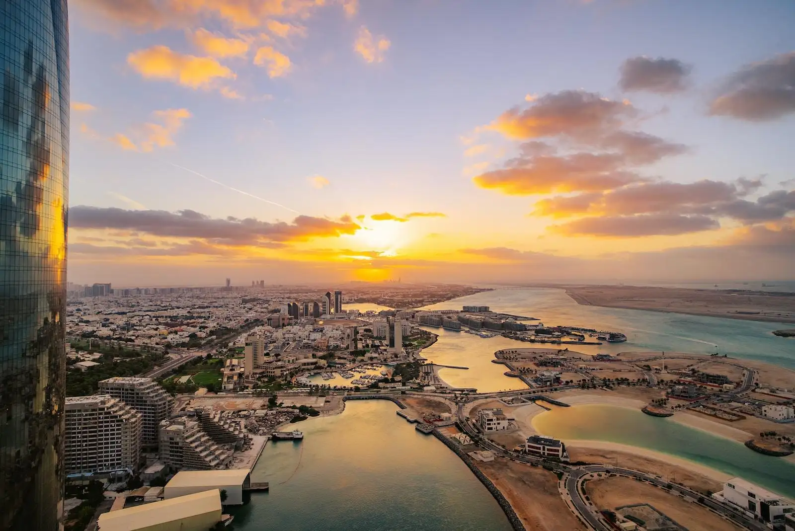 Photo by Gamze Teoman the sun is setting over a city and a body of water