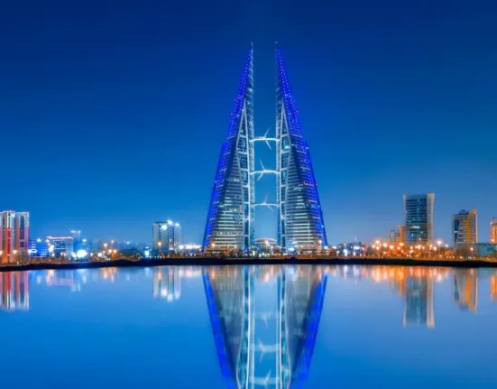 Blue and Purple Lighted Tower Near Body of Water during Night Time