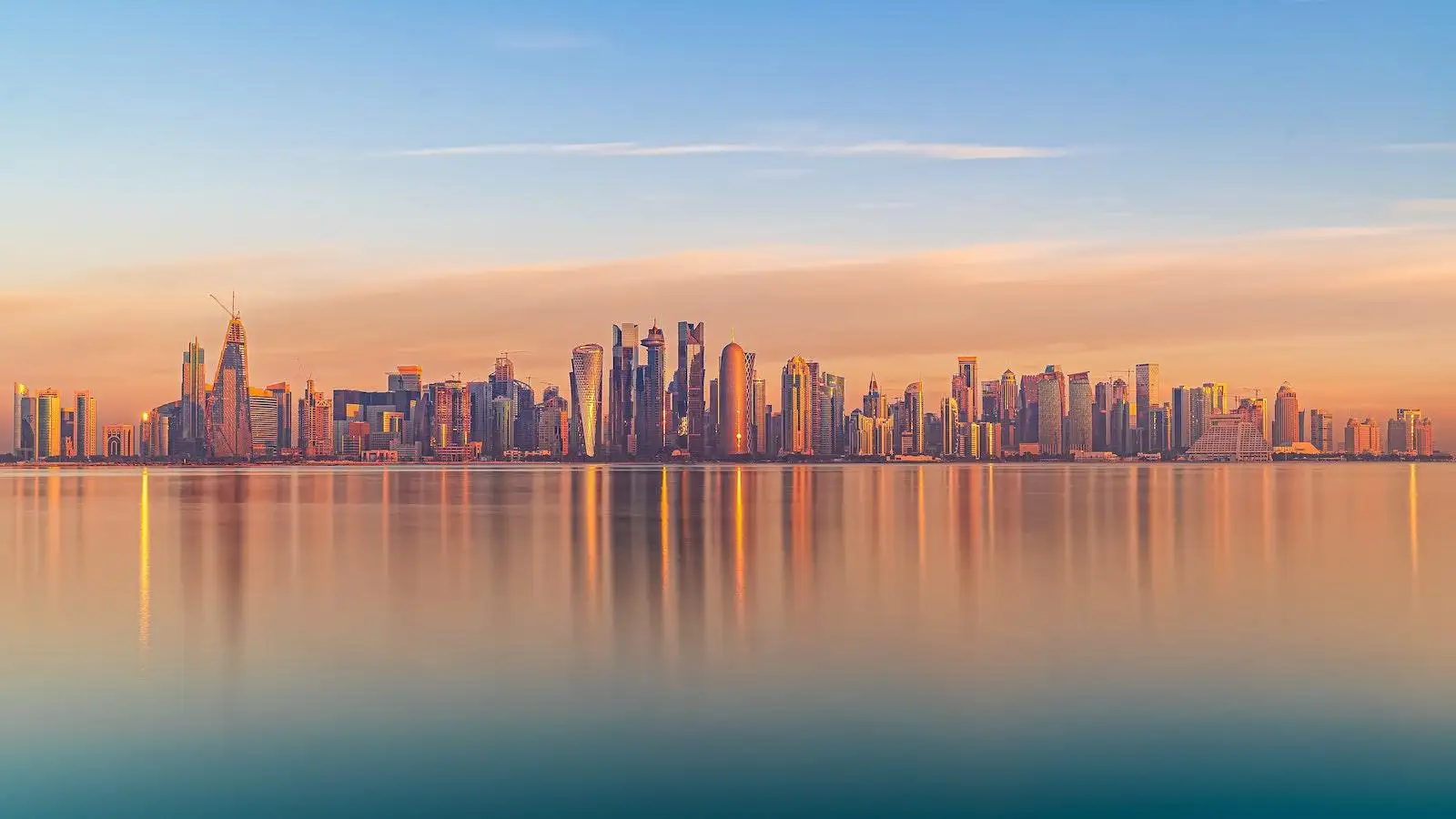 Scenic cityscape of modern coastal megapolis under sunset sky