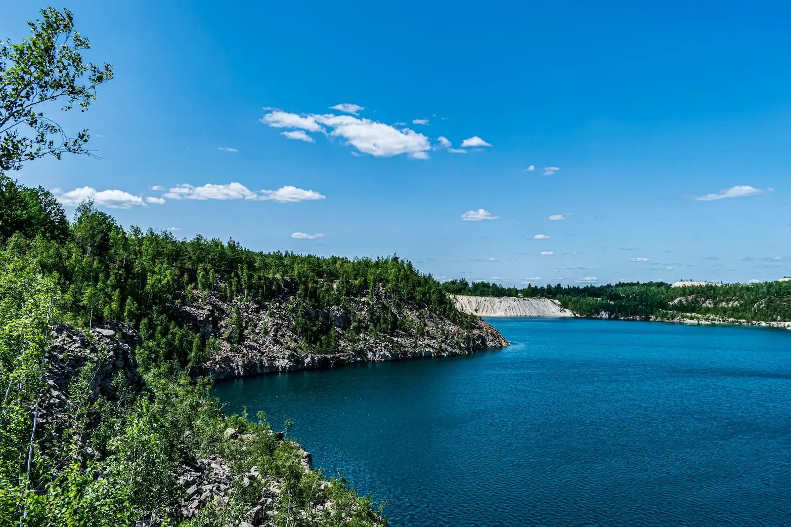 Photo by Kostiantyn Vierkieiev a large body of water surrounded by trees
