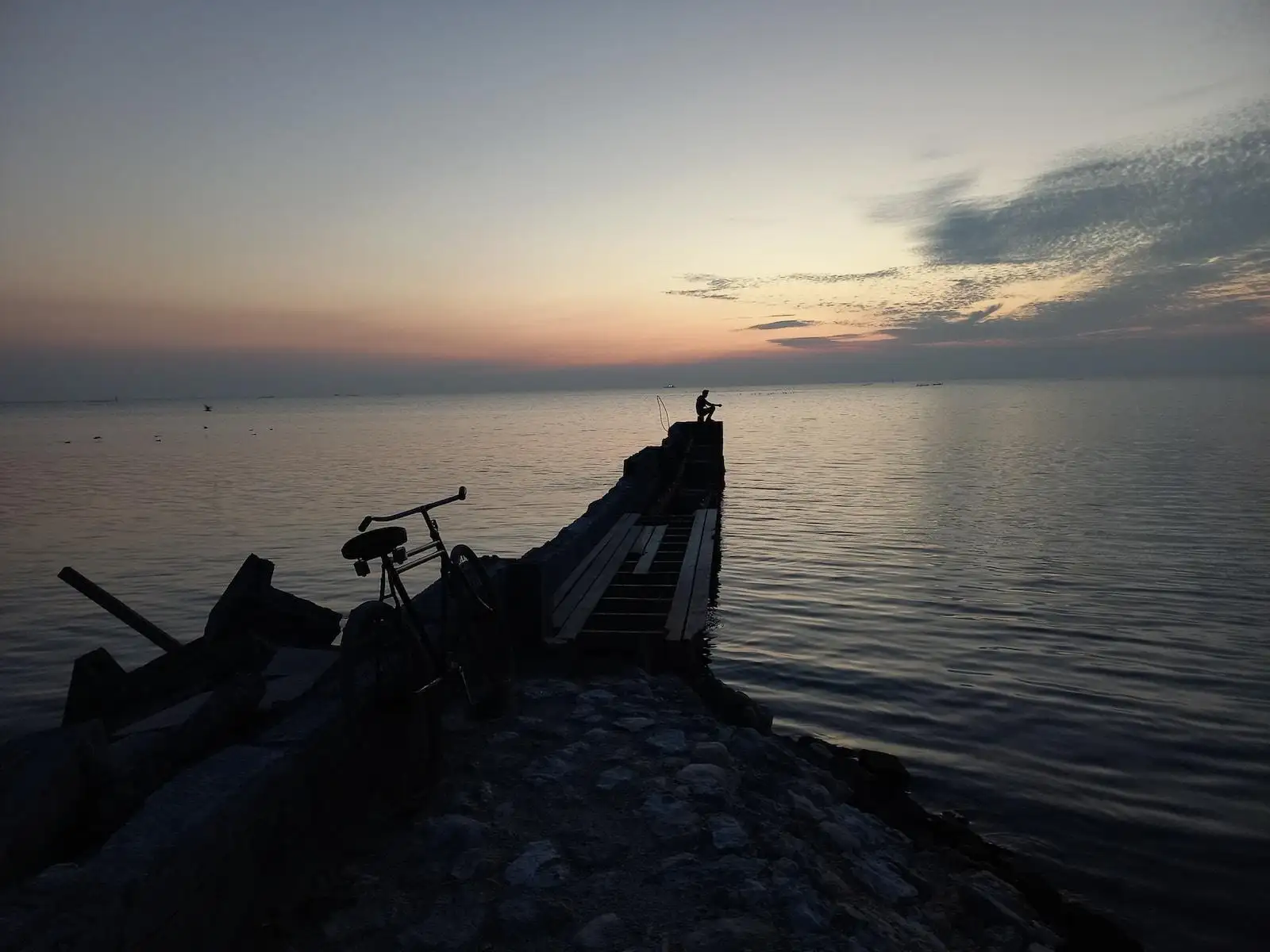Photo by Rizwan Ahmed a bike is parked on the edge of a pier