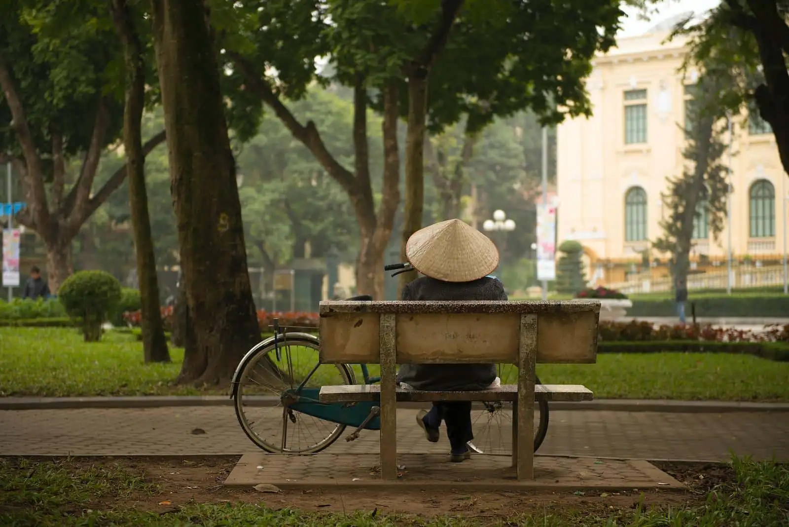 Photo by Lukasz Saczek person sitting on bench in front of commuter bike