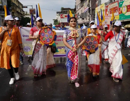 a group of people walking down a street holding flags