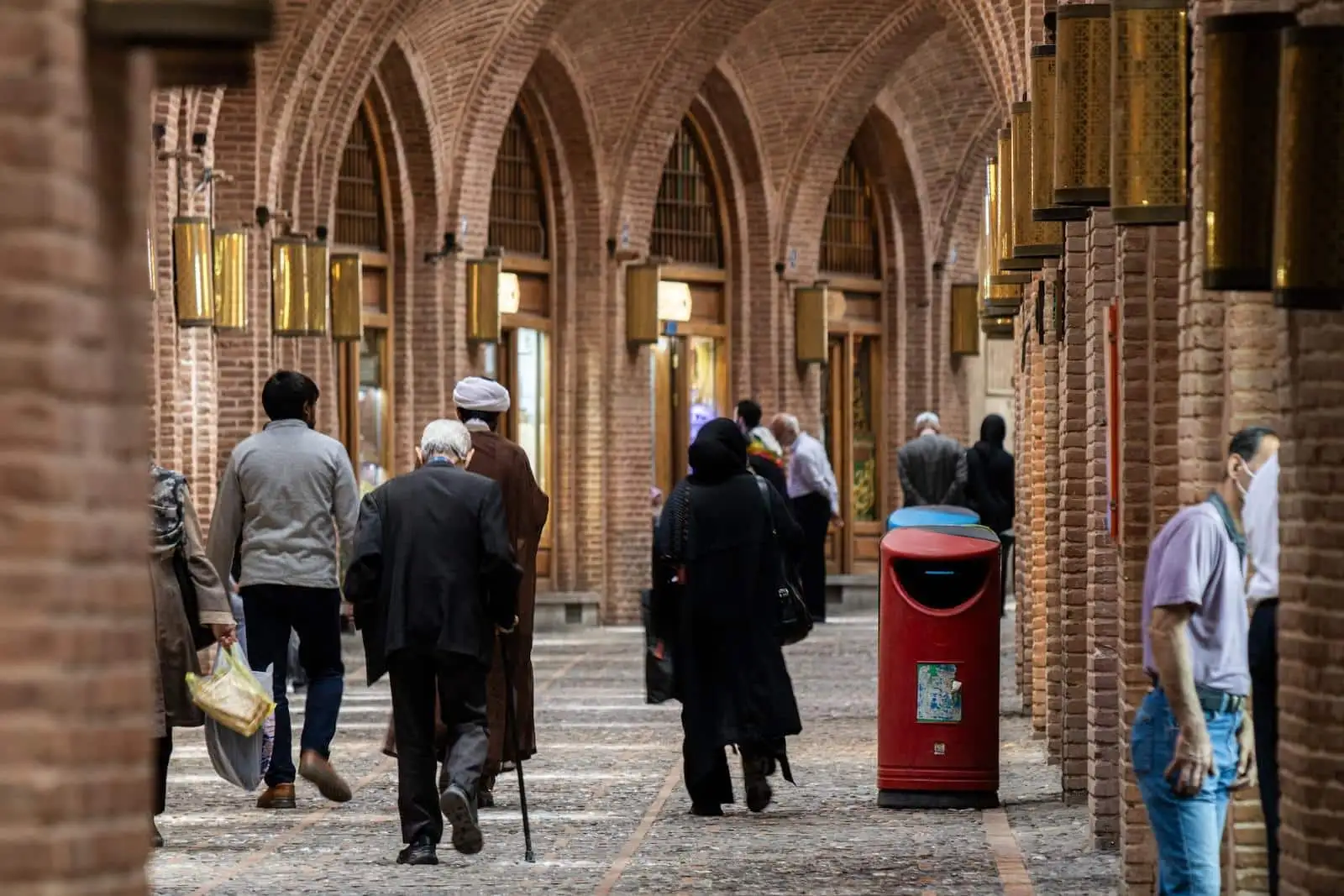 a group of people walking down a brick walkway
