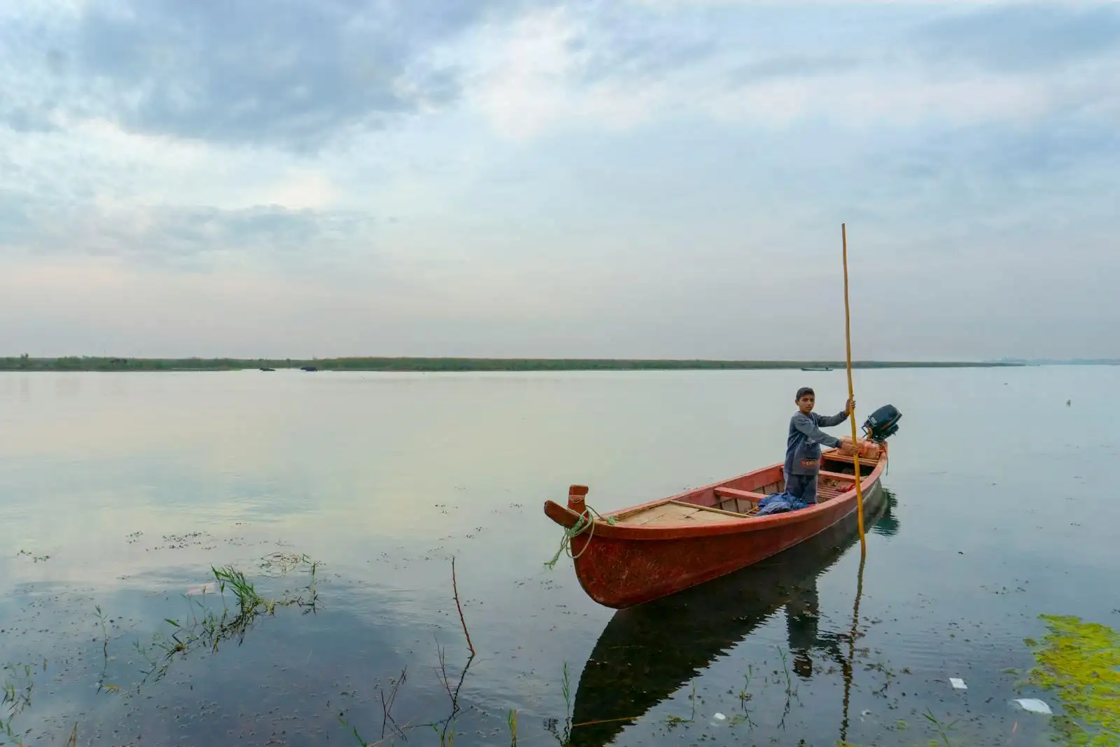 Photo by Karar Mhoder Boy Standing on Wooden Boat