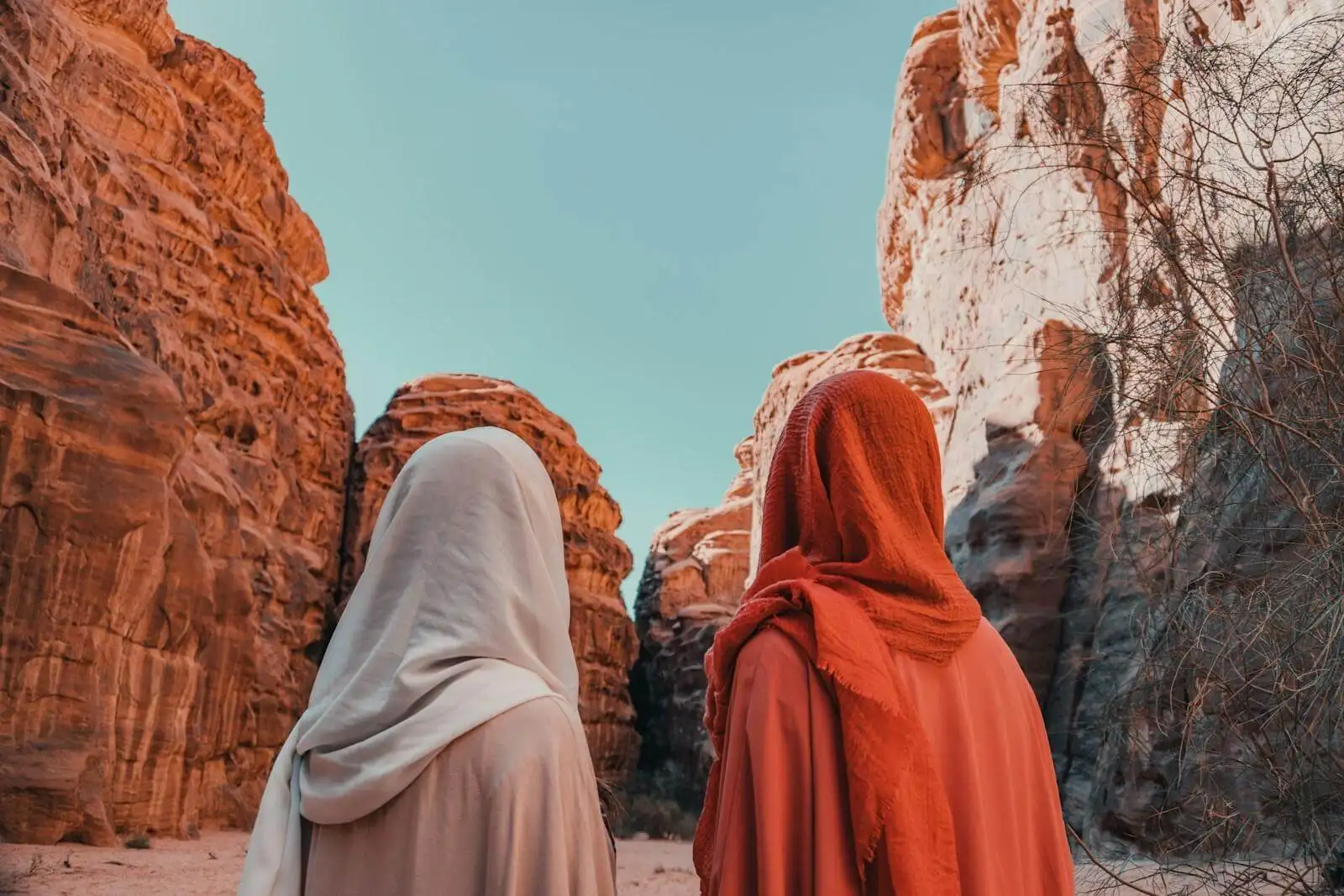 Photo by NEOM a couple of women standing next to each other