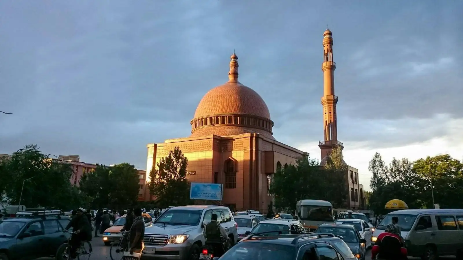 Photo by farin sadiq a group of cars parked in front of a tall building