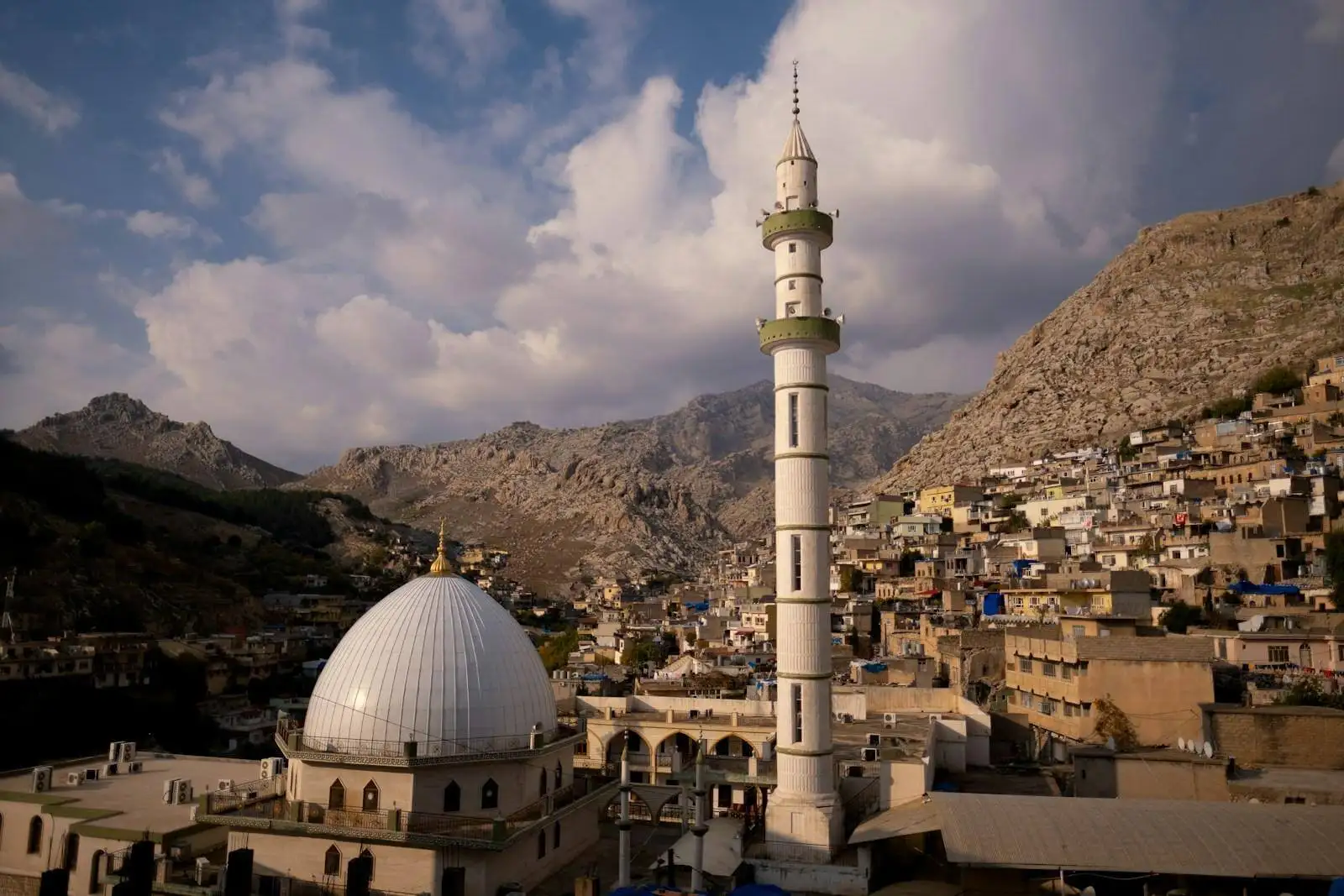 Photo by Levi Meir Clancy white concrete building near mountain under white clouds during daytime