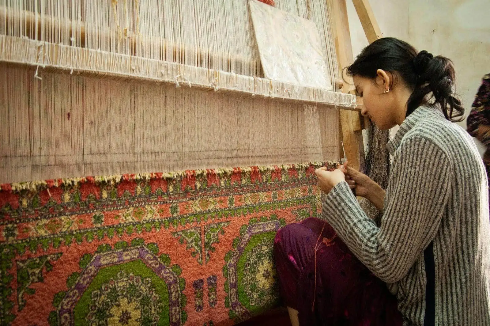 Photo by Joel Heard a woman is working on a weaving machine